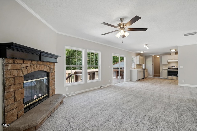 unfurnished living room with visible vents, ornamental molding, a textured ceiling, and a fireplace
