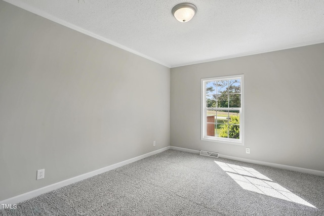 carpeted spare room featuring visible vents, ornamental molding, a textured ceiling, and baseboards