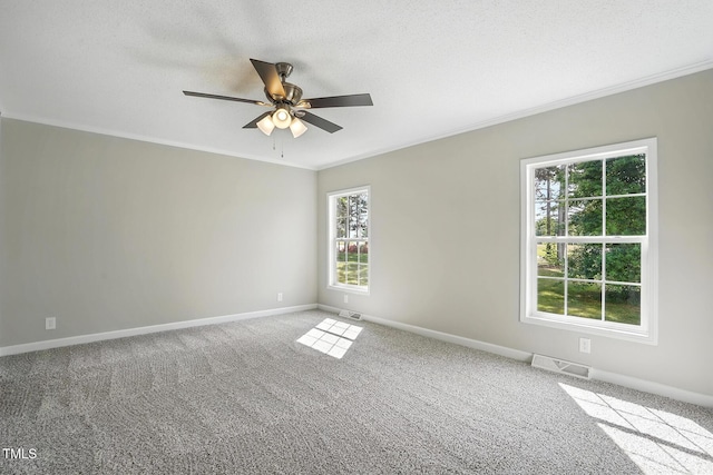 unfurnished room with crown molding, baseboards, a ceiling fan, and visible vents