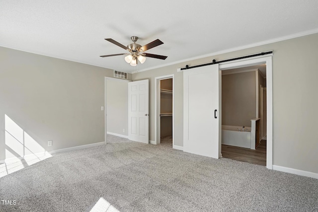 unfurnished bedroom with baseboards, ornamental molding, carpet, and visible vents
