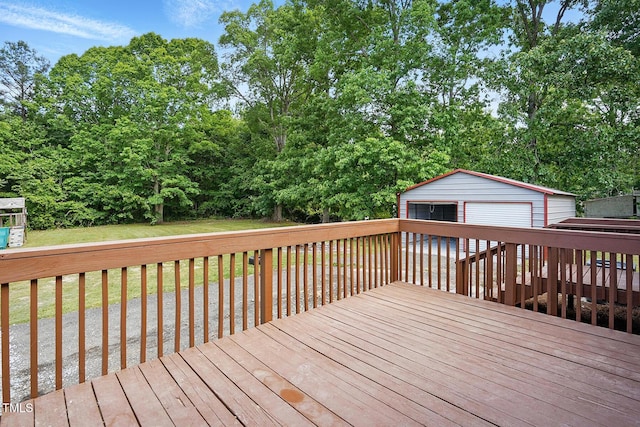wooden terrace featuring a detached garage, an outdoor structure, and a lawn