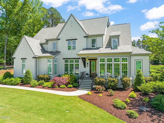 view of front of home featuring a shingled roof and a front yard