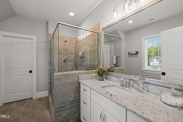 full bathroom with visible vents, lofted ceiling, vanity, and a shower stall