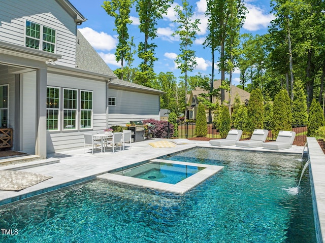 view of swimming pool with a fenced in pool, fence, an in ground hot tub, and a patio area