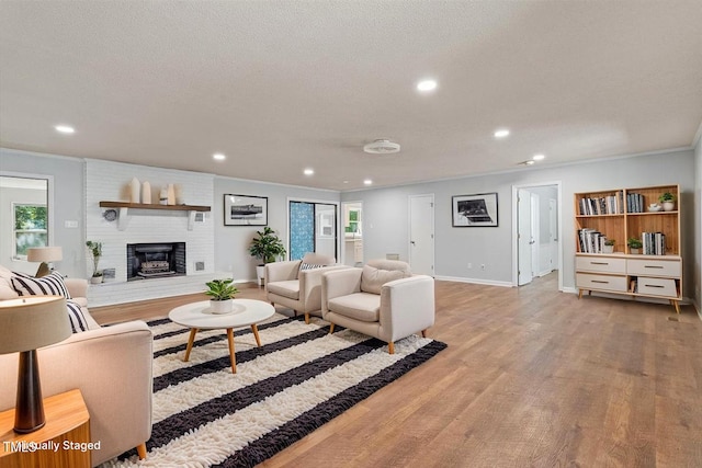 5124 Lazywood Ln, Durham, NC 27712 - living area featuring wood finished floors, recessed lighting, crown molding, a brick fireplace, and a textured ceiling