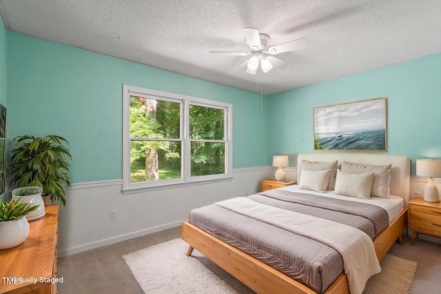 5124 Lazywood Ln, Durham, NC 27712 - carpeted bedroom featuring a wainscoted wall, a textured ceiling, and a ceiling fan