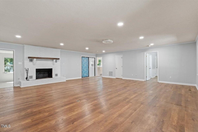 5124 Lazywood Ln, Durham, NC 27712 - unfurnished living room with recessed lighting, wood finished floors, a textured ceiling, ornamental molding, and a fireplace