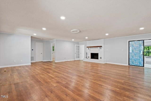 5124 Lazywood Ln, Durham, NC 27712 - unfurnished living room featuring light wood-style flooring, recessed lighting, ornamental molding, a fireplace, and a textured ceiling