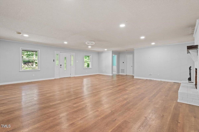5124 Lazywood Ln, Durham, NC 27712 - unfurnished living room featuring recessed lighting, light wood finished floors, crown molding, a fireplace, and a textured ceiling