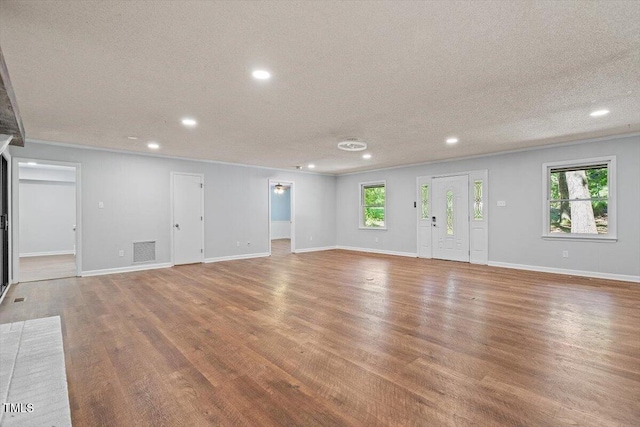 5124 Lazywood Ln, Durham, NC 27712 - unfurnished living room featuring recessed lighting, wood finished floors, a textured ceiling, and crown molding
