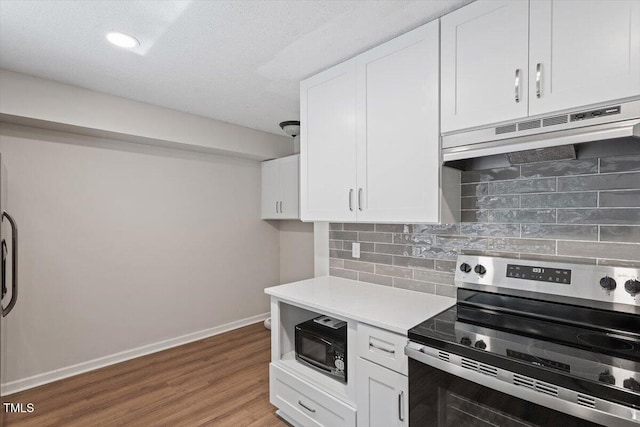 5124 Lazywood Ln, Durham, NC 27712 - kitchen featuring stainless steel electric range, black microwave, under cabinet range hood, white cabinetry, and recessed lighting
