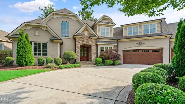 view of front of property featuring concrete driveway, an attached garage, and roof with shingles