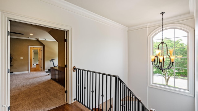 hall featuring a chandelier, an upstairs landing, crown molding, plenty of natural light, and baseboards