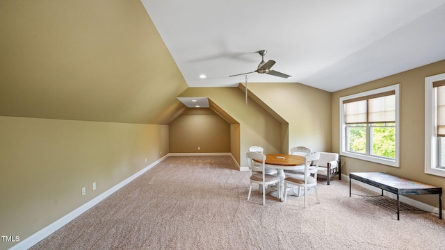 carpeted dining room featuring vaulted ceiling, baseboards, and a ceiling fan