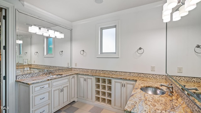 full bathroom with healthy amount of natural light, double vanity, and a chandelier