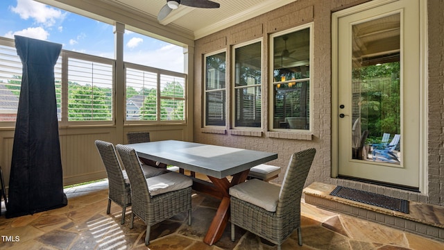 sunroom / solarium featuring crown molding and stone finish floors