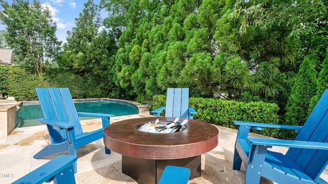 outdoor pool with a fire pit and a patio