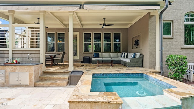 view of pool with a patio, ceiling fan, an outdoor living space, a sink, and a swimming pool