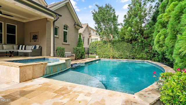 view of swimming pool featuring outdoor lounge area, a pool with connected hot tub, and a patio area