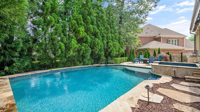 outdoor pool with a patio and an outdoor hot tub