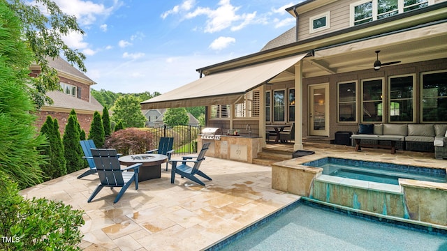 view of swimming pool with an outdoor kitchen, a patio, an outdoor living space with a fire pit, and a pool with connected hot tub