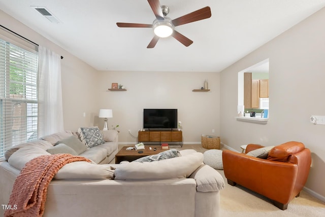living room featuring visible vents, a ceiling fan, and baseboards
