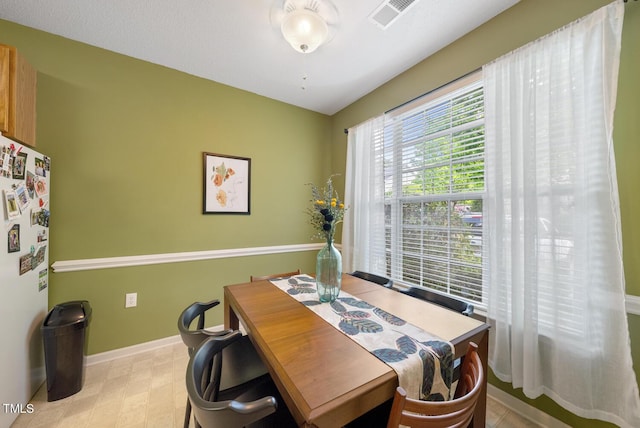 dining room with light floors, visible vents, and baseboards