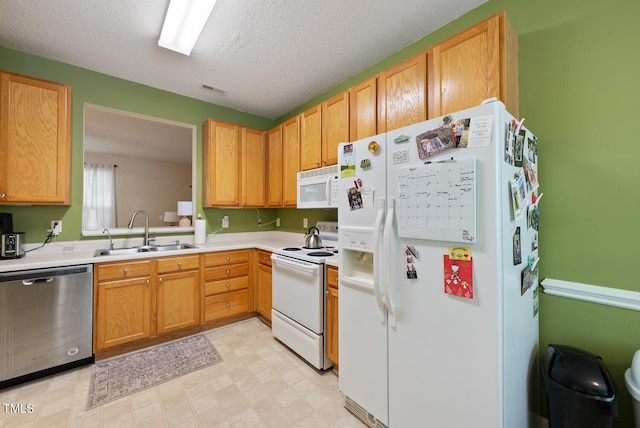kitchen featuring a sink, white appliances, visible vents, light countertops, and a textured ceiling