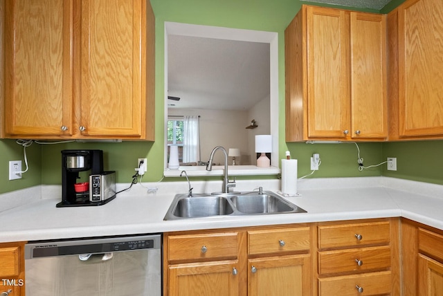 kitchen with a sink, dishwasher, and light countertops