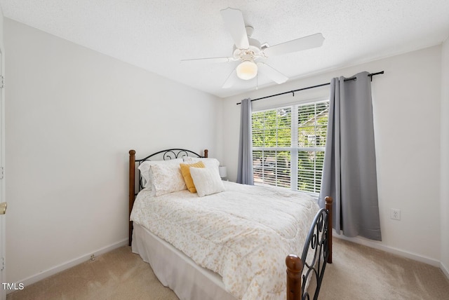 bedroom with a ceiling fan, light carpet, and baseboards