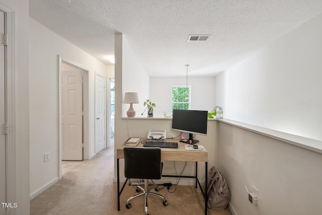 office area featuring carpet, visible vents, baseboards, and a textured ceiling