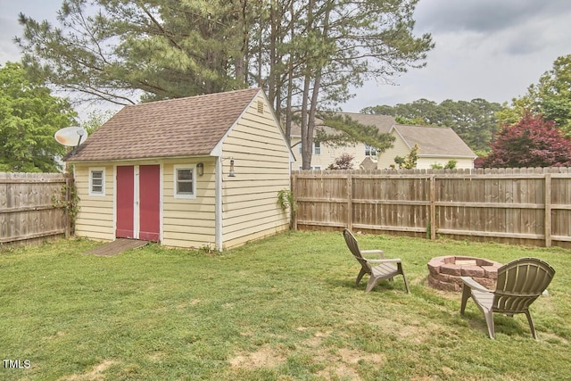 view of shed with a fenced backyard and an outdoor fire pit