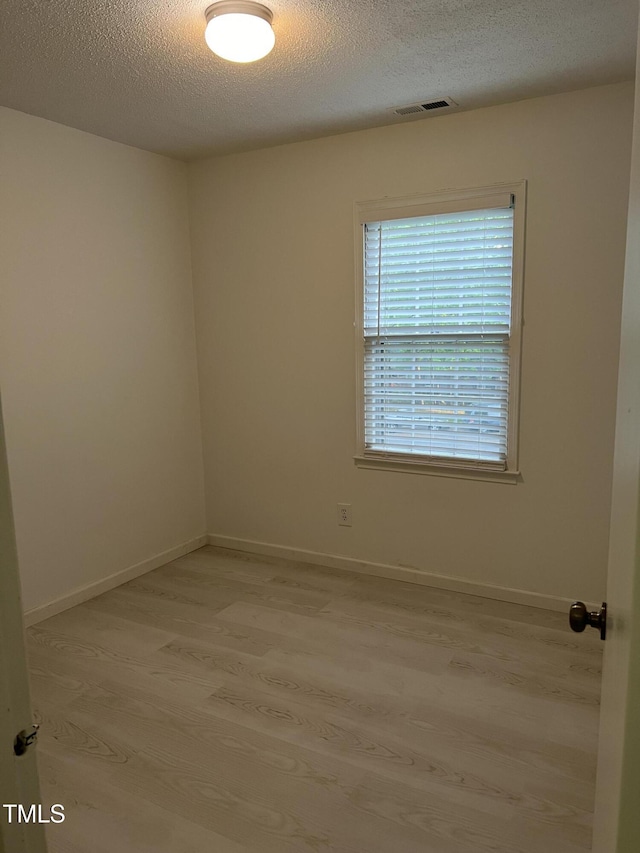 7412 Barberry Ct, Raleigh, NC 27615 - spare room with light wood finished floors, a textured ceiling, and baseboards