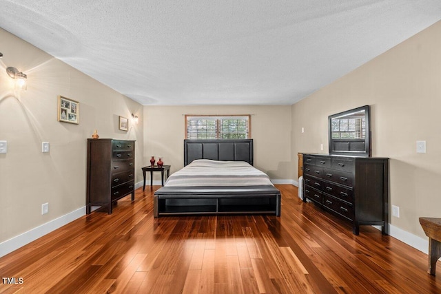 bedroom featuring baseboards, a textured ceiling, and hardwood / wood-style flooring