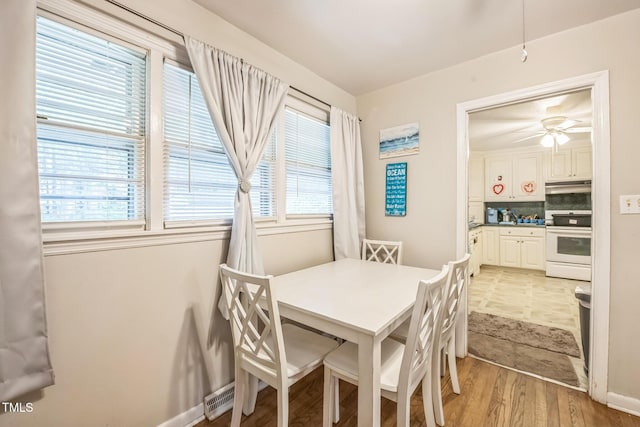 dining room with light wood-type flooring and a ceiling fan