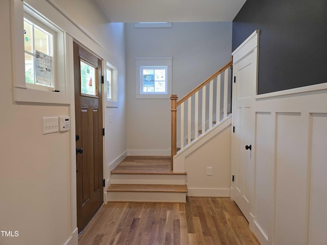 entrance foyer featuring wood finished floors, stairs, and baseboards