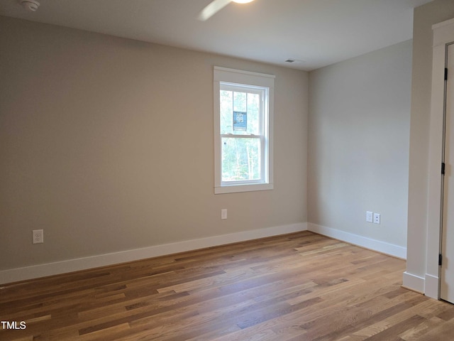 spare room with wood finished floors, baseboards, and a smoke detector