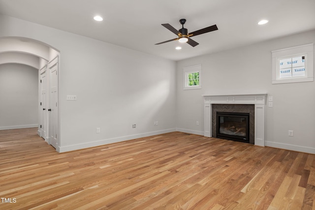 1005 Forrestal Pl, Durham, NC 27707 - unfurnished living room with ceiling fan, a fireplace, light wood finished floors, recessed lighting, and arched walkways