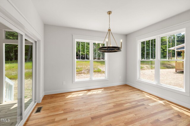 1005 Forrestal Pl, Durham, NC 27707 - unfurnished dining area with a chandelier, plenty of natural light, and light wood finished floors
