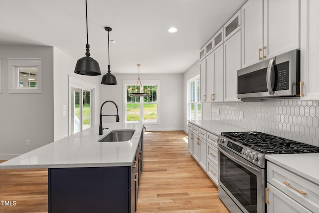 1005 Forrestal Pl, Durham, NC 27707 - kitchen featuring appliances with stainless steel finishes, light wood finished floors, decorative backsplash, white cabinets, and recessed lighting