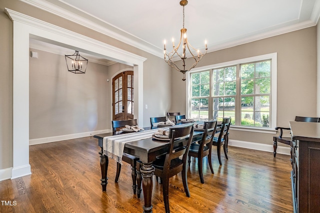 dining area featuring an inviting chandelier, dark wood-style flooring, french doors, and ornamental molding
