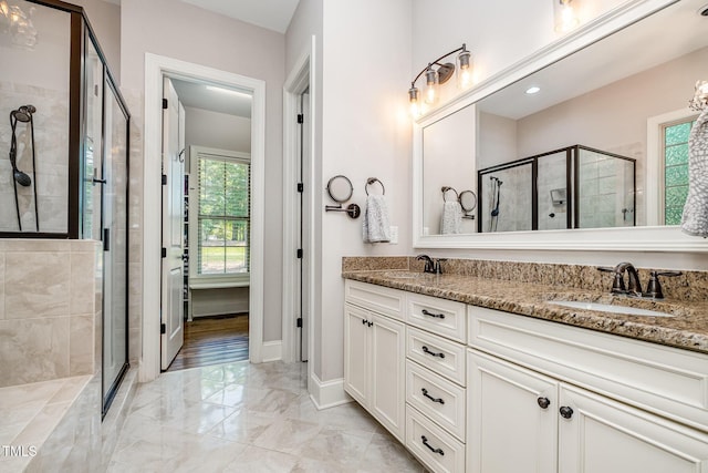 bathroom with a sink, double vanity, a shower stall, and marble finish floor