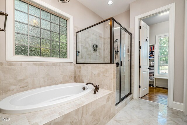 bathroom with a garden tub, marble finish floor, and a stall shower