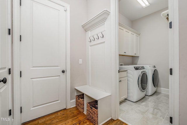 laundry room featuring baseboards, washer and dryer, and cabinet space