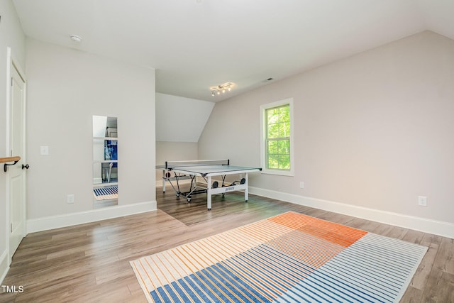 bedroom featuring light wood-style floors, baseboards, and lofted ceiling