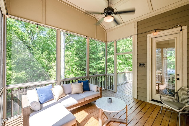 sunroom with a ceiling fan and an outdoor living space