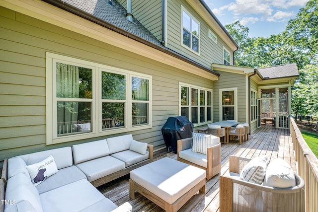 wooden deck with an outdoor hangout area and a grill