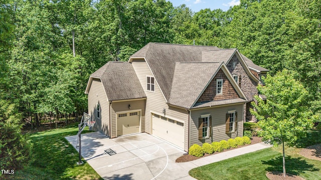 craftsman-style home featuring concrete driveway, a shingled roof, a garage, and a front lawn