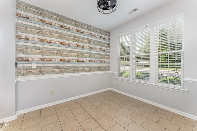 unfurnished room with baseboards and visible vents