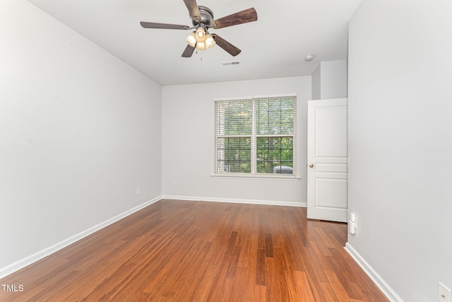unfurnished room featuring baseboards, ceiling fan, wood finished floors, and visible vents
